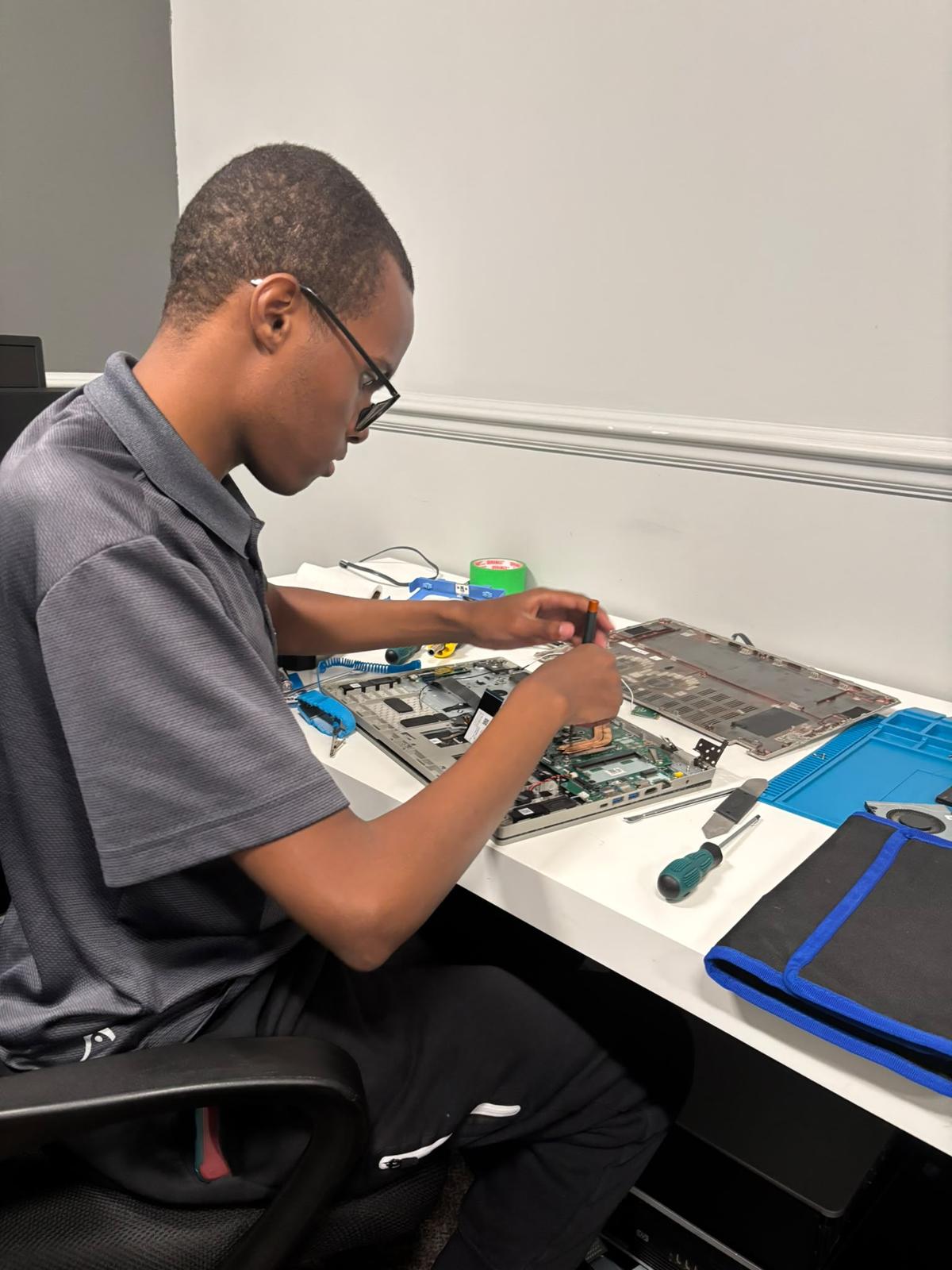 A participant practising computer hardware skills at a workbench